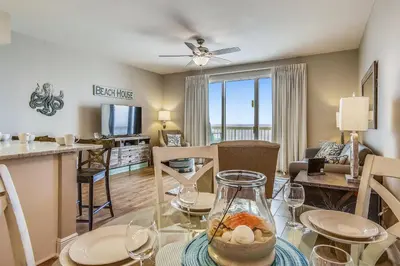 a living room with a table and a dining room at Celadon Beach Resort #1104 by Book That Condo in Panama City Beach