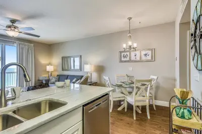 a kitchen and dining room with a sink and a table at Celadon Beach Resort #1104 by Book That Condo in Panama City Beach