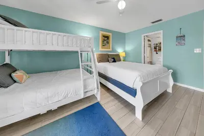 two bunk beds in a bedroom with blue walls at Edgewater Golf Villa 1409 in Panama City Beach