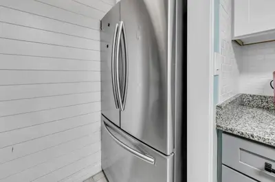 a stainless steel refrigerator in a kitchen with white walls at Edgewater Golf Villa 1409 in Panama City Beach
