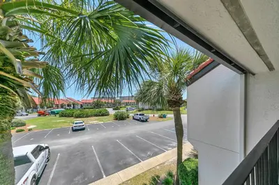 a view of a parking lot with a palm tree at Edgewater Golf Villa 1409 in Panama City Beach