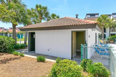 a small white house with a gate in a yard at Edgewater Golf Villa 1409 in Panama City Beach