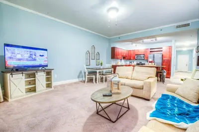 a living room with a couch and a table with a tv at Large 3 Bd Penthouse 2034 In Laketown, Great Views and Amenities! in Panama City Beach