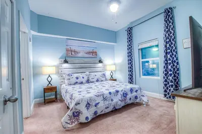 a blue bedroom with a bed and a window at Large 3 Bd Penthouse 2034 In Laketown, Great Views and Amenities! in Panama City Beach