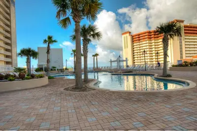 a swimming pool with palm trees and buildings at BEAUTIFUL 3 BD Laketown Wharf 1133- Best Amenities! in Panama City Beach