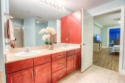 a bathroom with two sinks and a large mirror at Laketown Wharf 1238 - Brand New End Unit With Wrap Around Balcony in Panama City Beach