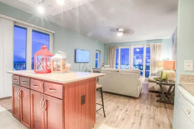 a living room with a kitchen and a living room with a couch at Laketown Wharf 1238 - Brand New End Unit With Wrap Around Balcony in Panama City Beach
