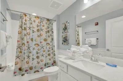 a bathroom with a toilet and a shower curtain at Calypso 3-205 in Panama City Beach