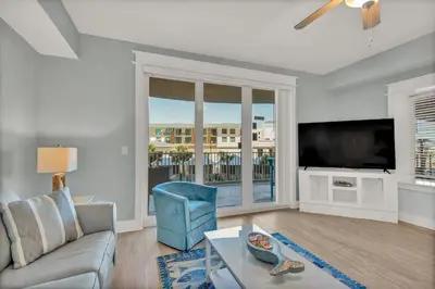 a living room with a couch and a flat screen tv at Calypso 3-205 in Panama City Beach