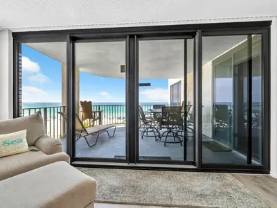 a living room with sliding glass doors on a balcony at Watercrest 402 in Panama City Beach