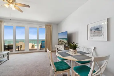 a dining room with a table and chairs with a view of the ocean at Spacious Resort Condo with Breathtaking Gulf Views! by Dolce Vita Getaways PCB in Panama City Beach