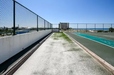 an empty tennis court with a fence and a tennis court at Watercrest #1206 by Book That Condo in Panama City Beach