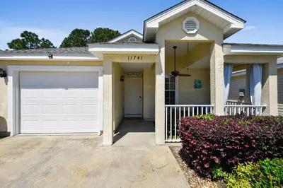 a house with a white garage door and a driveway at The Sandbox by Book That Condo in Panama City Beach
