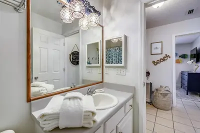 a bathroom with a sink and a mirror at The Sandbox by Book That Condo in Panama City Beach