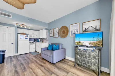 a living room with a tv and a couch and a kitchen at Majestic Beach Towers 1-2109 in Panama City Beach