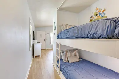 a bedroom with a bunk bed with blue sheets at PCB Resort Condo with Private Balcony and 3 Pools! in Panama City Beach