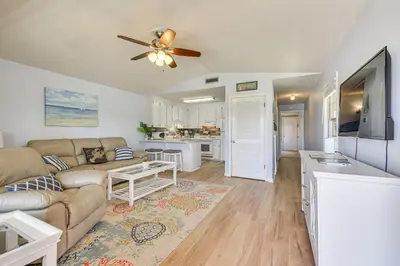 a living room with a couch and a tv at PCB Resort Condo with Private Balcony and 3 Pools! in Panama City Beach