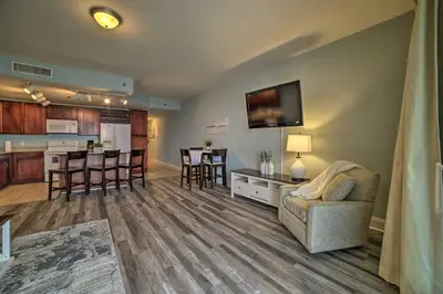 a living room with a couch and a kitchen at 18th-Floor PCB Resort Condo with Amazing Gulf View! in Panama City Beach