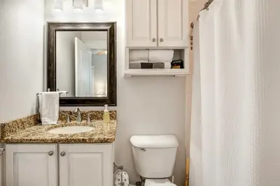a bathroom with a sink and a toilet and a mirror at Sea It All in Santa Rosa Beach