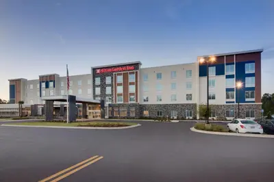 a building with a parking lot in front of it at Hilton Garden Inn Panama City Airport, Fl in Panama City