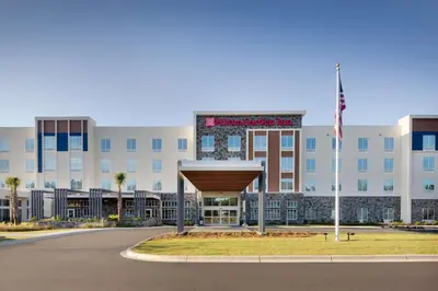 a hospital building with an american flag in front of it at Hilton Garden Inn Panama City Airport, Fl in Panama City