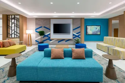 a living room with a blue couch and a tv at Hilton Garden Inn Panama City Airport, Fl in Panama City