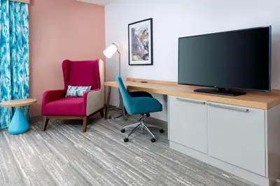 a room with a desk with a television and two chairs at Hilton Garden Inn Panama City Airport, Fl in Panama City