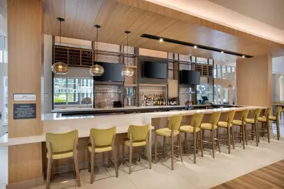 a bar in a restaurant with yellow bar stools at Hilton Garden Inn Panama City Airport, Fl in Panama City