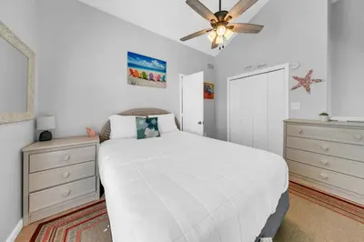 a bedroom with a white bed and a ceiling fan at Endless Summer F9 in Panama City Beach