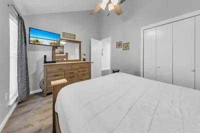 a white bedroom with a large bed and a dresser at Endless Summer F9 in Panama City Beach
