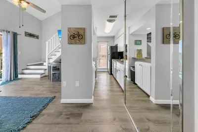 a kitchen with white walls and a glass hallway at Endless Summer F9 in Panama City Beach