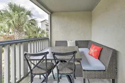 a patio with a table and chairs on a balcony at Panama City Condo with Balcony and Pool, Walk to Beach in Panama City Beach