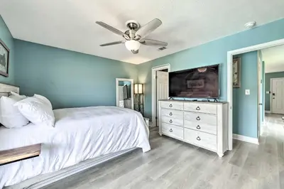 a bedroom with a bed and a ceiling fan at Panama City Condo with Balcony and Pool, Walk to Beach in Panama City Beach