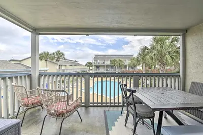 a balcony with a table and chairs and a pool at Panama City Condo with Balcony and Pool, Walk to Beach in Panama City Beach