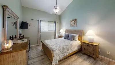 a bedroom with a bed and a dresser and a mirror at Nautical Watch Gulf Side Villas B-13 in Panama City Beach