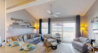 a living room with a couch and a table and chairs at Nautical Watch Gulf Side Villas B-13 in Panama City Beach