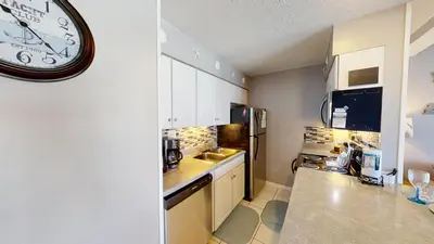 a kitchen with a large clock on the wall at Nautical Watch Gulf Side Villas B-13 in Panama City Beach