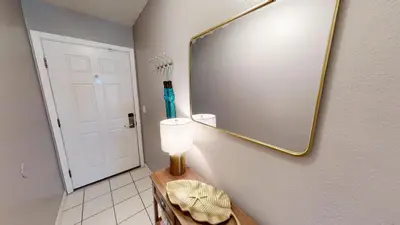 a bathroom with a mirror and a lamp on a wall at Nautical Watch Gulf Side Villas B-13 in Panama City Beach