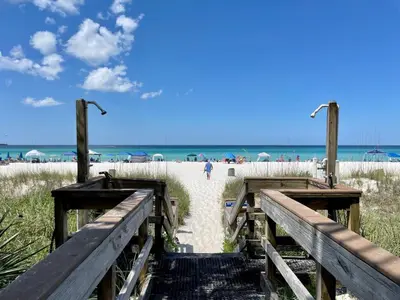 a boardwalk to the beach with people walking on it at Nautical Watch Gulf Side Villas B-13 in Panama City Beach