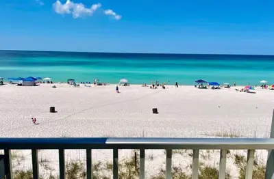 a beach with people and umbrellas and the ocean at Nautical Watch Gulf Side Villas B-13 in Panama City Beach