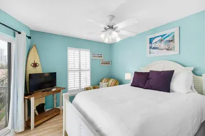 a bedroom with blue walls and a bed and a tv at Rollin Tide Villas- Rollin Tide B9 in Santa Rosa Beach