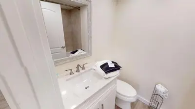 a bathroom with a sink and a toilet and a mirror at Dunes of Panama E-1006 in Panama City Beach