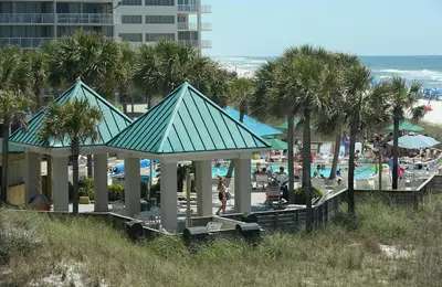 a group of gazebos at a beach with palm trees at Dunes of Panama E-1006 in Panama City Beach