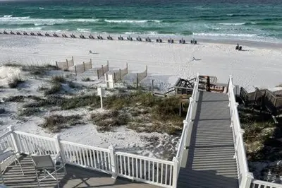a boardwalk leading to a beach with people in the water at Ocean Air Upper West Private Beach Unit on 30A in Santa Rosa Beach