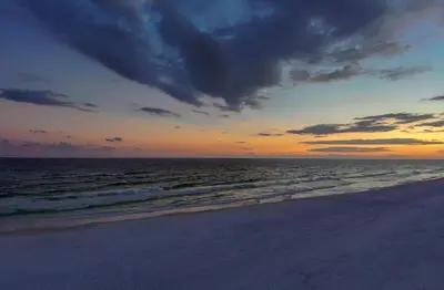 a sunset on a beach with the ocean at Ocean Air Upper West Private Beach Unit on 30A in Santa Rosa Beach