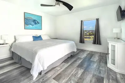a white bedroom with a large bed and windows at Ocean Air Upper East Private Beach unit on 30A in Santa Rosa Beach