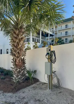 a electrical box next to a palm tree and a building at Ocean Air Upper East Private Beach unit on 30A in Santa Rosa Beach