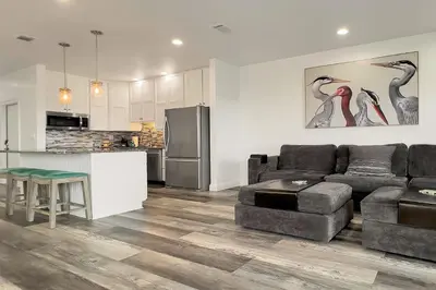 a living room with a couch and a kitchen at Ocean Air Lower West Private Beach Unit on 30A in Santa Rosa Beach