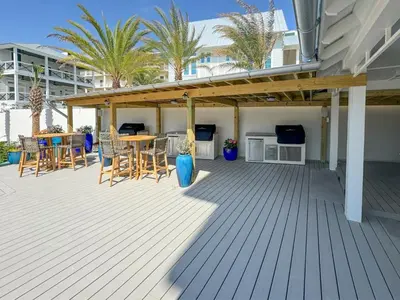 a patio with a table and chairs on a deck at Ocean Air Lower West Private Beach Unit on 30A in Santa Rosa Beach