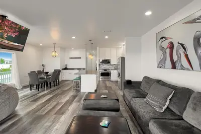 a living room and kitchen with a couch and a table at Ocean Air Lower West Private Beach Unit on 30A in Santa Rosa Beach